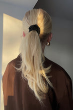 Load image into Gallery viewer, Blond girl wearing a black silk scrunchie in her beautiful ponytail, sun shining on her hair
