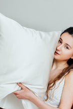 Load image into Gallery viewer, A dark haired girl holding white silk pillowcase gently

