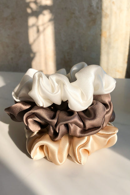 Sun beautifully shining on a set of natural silk scrunchies - cappuccino beige, delicious mocha & white pearl  Katrina Silks   