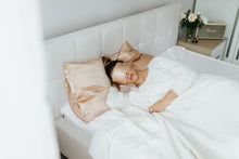 Load image into Gallery viewer, In the early hours, a girl wakes up in bed, covered by a luxurious silk sleep mask.
