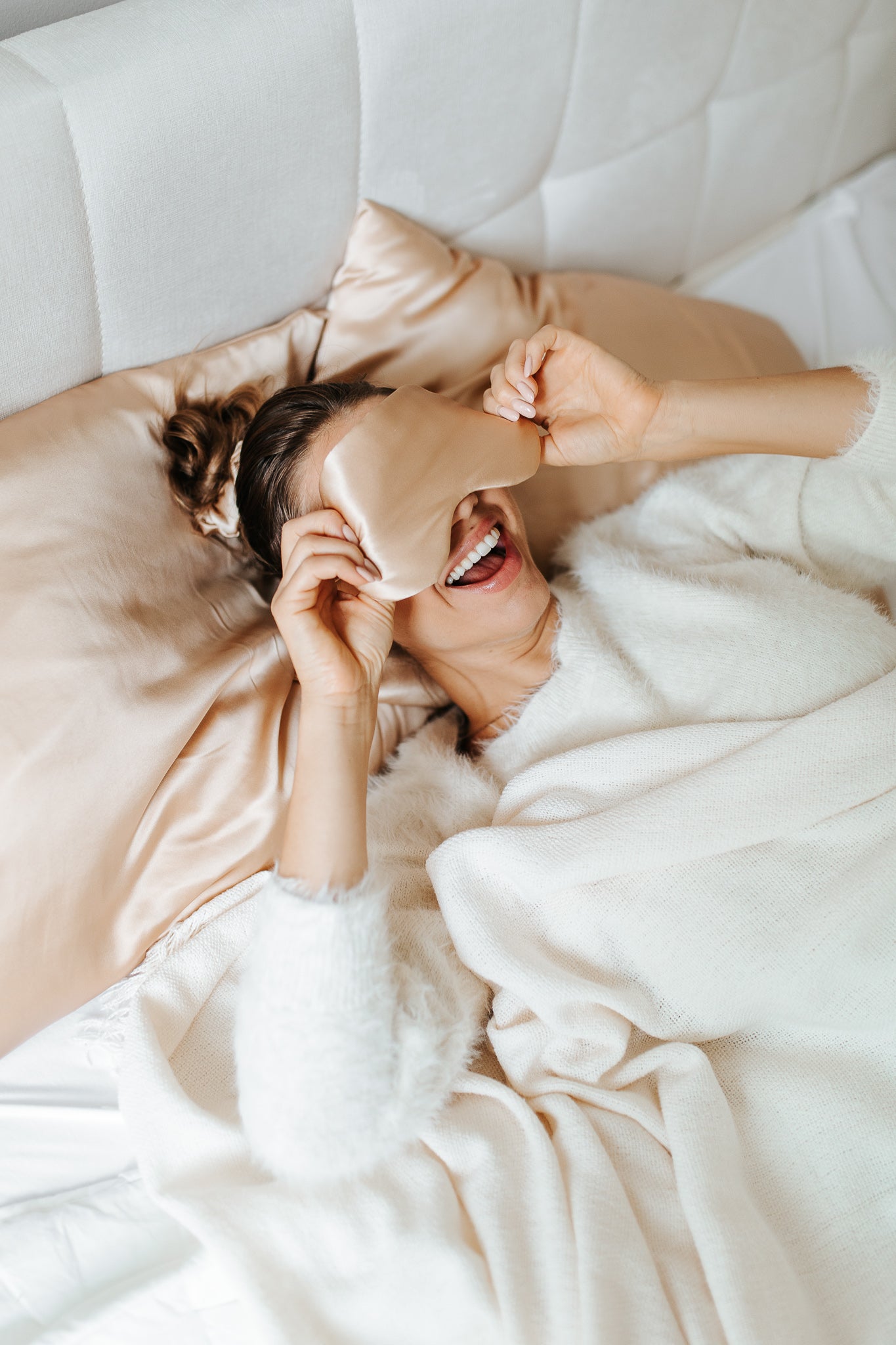 Awakened by the dawn, a young girl rises from slumber, adorned with a sumptuous beige silk sleep mask. A radiant joy dances in her countenance, and contentment wraps her in a morning embrace.