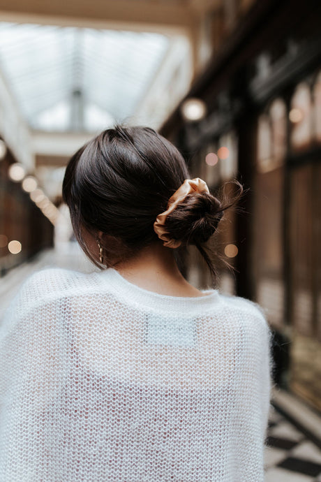 Girl with dark hair and gold natural silk scrunchie in low bun