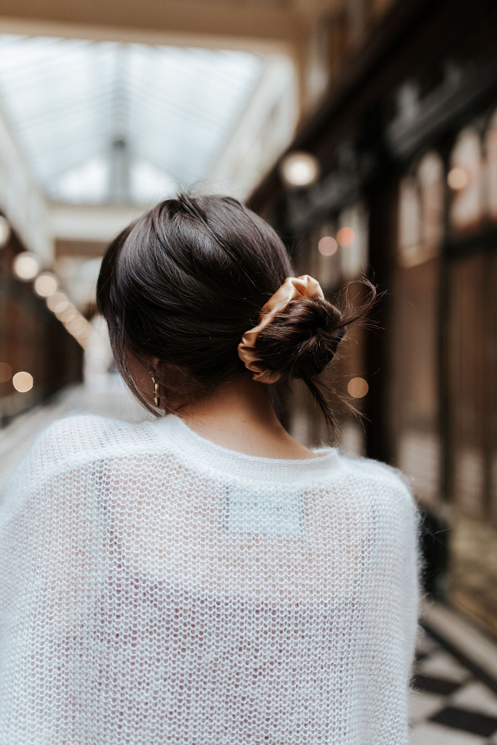 Girl with dark hair and gold natural silk scrunchie in low bun